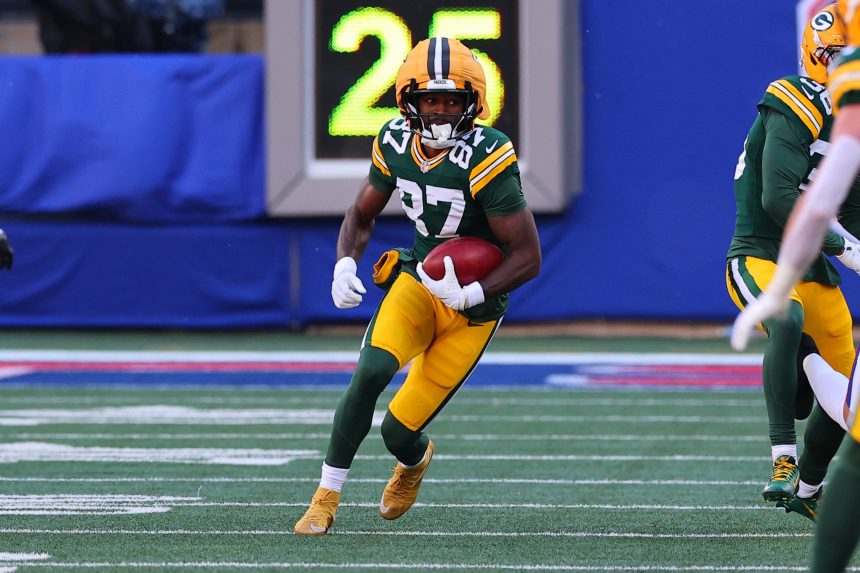 Der Wide Receiver der Packers, Romeo Doubs, läuft während eines Spiels in der grün-gelben Uniform des Teams mit dem Ball. Alt-Text wurde KI-generiert.