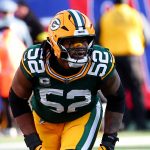 Rashan Gary, Footballspieler der Green Bay Packers, trägt die Nummer 52 und ein grünes Trikot und bereitet sich während eines Spiels gegen die Cowboys auf einen Spielzug auf dem Feld vor. Alt-Text wurde KI-generiert.