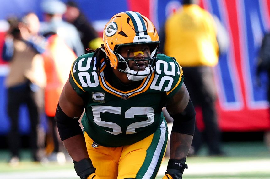 Rashan Gary, Footballspieler der Green Bay Packers, trägt die Nummer 52 und ein grünes Trikot und bereitet sich während eines Spiels gegen die Cowboys auf einen Spielzug auf dem Feld vor. Alt-Text wurde KI-generiert.