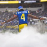 American-Football-Spieler Witherspoon von den Los Angeles Rams läuft durch Nebel auf das Spielfeld, Rückenansicht mit Nummer 4