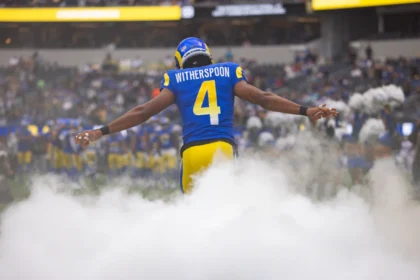 American-Football-Spieler Witherspoon von den Los Angeles Rams läuft durch Nebel auf das Spielfeld, Rückenansicht mit Nummer 4