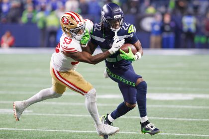 Rashid Shaheed - Ein Spieler der San Francisco 49ers versucht während eines NFL-Spiels, einen Football tragenden Spieler der Seahawks zu attackieren. Alt-Text wurde KI-generiert.
