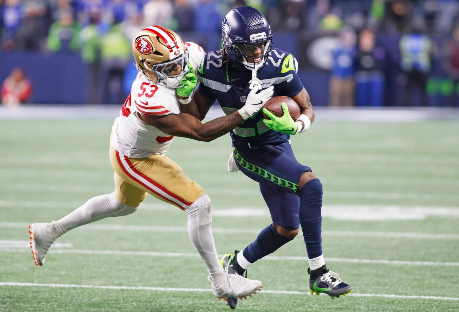 Rashid Shaheed - Ein Spieler der San Francisco 49ers versucht während eines NFL-Spiels, einen Football tragenden Spieler der Seahawks zu attackieren. Alt-Text wurde KI-generiert.