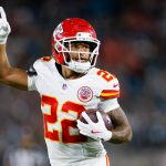 Chiefs-Star Trent McDuffie, der die Nummer 22 trägt, läuft mit dem Ball und zeigt nach oben während eines intensiven Spiels gegen die Rams. Alt-Text wurde KI-generiert.