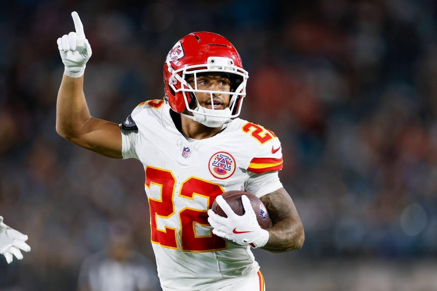 Chiefs-Star Trent McDuffie, der die Nummer 22 trägt, läuft mit dem Ball und zeigt nach oben während eines intensiven Spiels gegen die Rams. Alt-Text wurde KI-generiert.