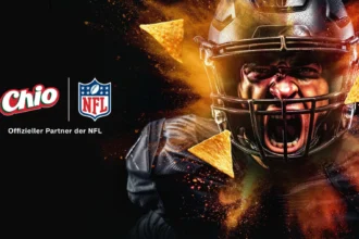 Ein Footballspieler in schwarzer Kleidung schreit, während orangefarbene Snackchips um ihn herumfliegen. Auf der linken Seite erscheinen die Logos von Chio und NFL Deutschland mit dem Text "Offizieller Partner der NFL. Alt-Text wurde KI-generiert.