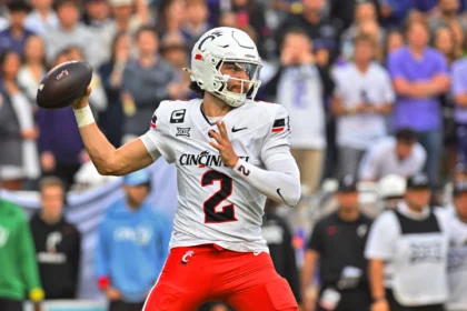 Der Footballspieler der Cincinnati Bearcats, Brendan Sorsby (weißes Trikot mit der Nummer 2), bereitet sich während eines Spiels auf einen Pass vor, im Hintergrund ist das Publikum zu sehen – ein potenzieller Kandidat für den NFL Supplemental Draft 2026. Alt-Text wurde KI-generiert.