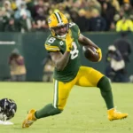 Josh Jacobs - Ein Spieler der Green Bay Packers läuft mit dem Football davon, während ein Verteidiger der Chicago Bears hinter ihm zurückbleibt – und das gerade in dem Moment, in dem die NFL Jacobs auf die Liste der Schlüsselspieler setzt. Alt-Text wurde KI-generiert.