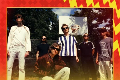Sechs Bandmitglieder von Cage the Elephant stehen unter strahlend blauem Himmel auf einem Basketballplatz im Freien. Der Text wirbt für ihren Halbzeitshow-Auftritt beim NFL-Spiel in München 2026 am 15. November. Alt-Text wurde KI-generiert.