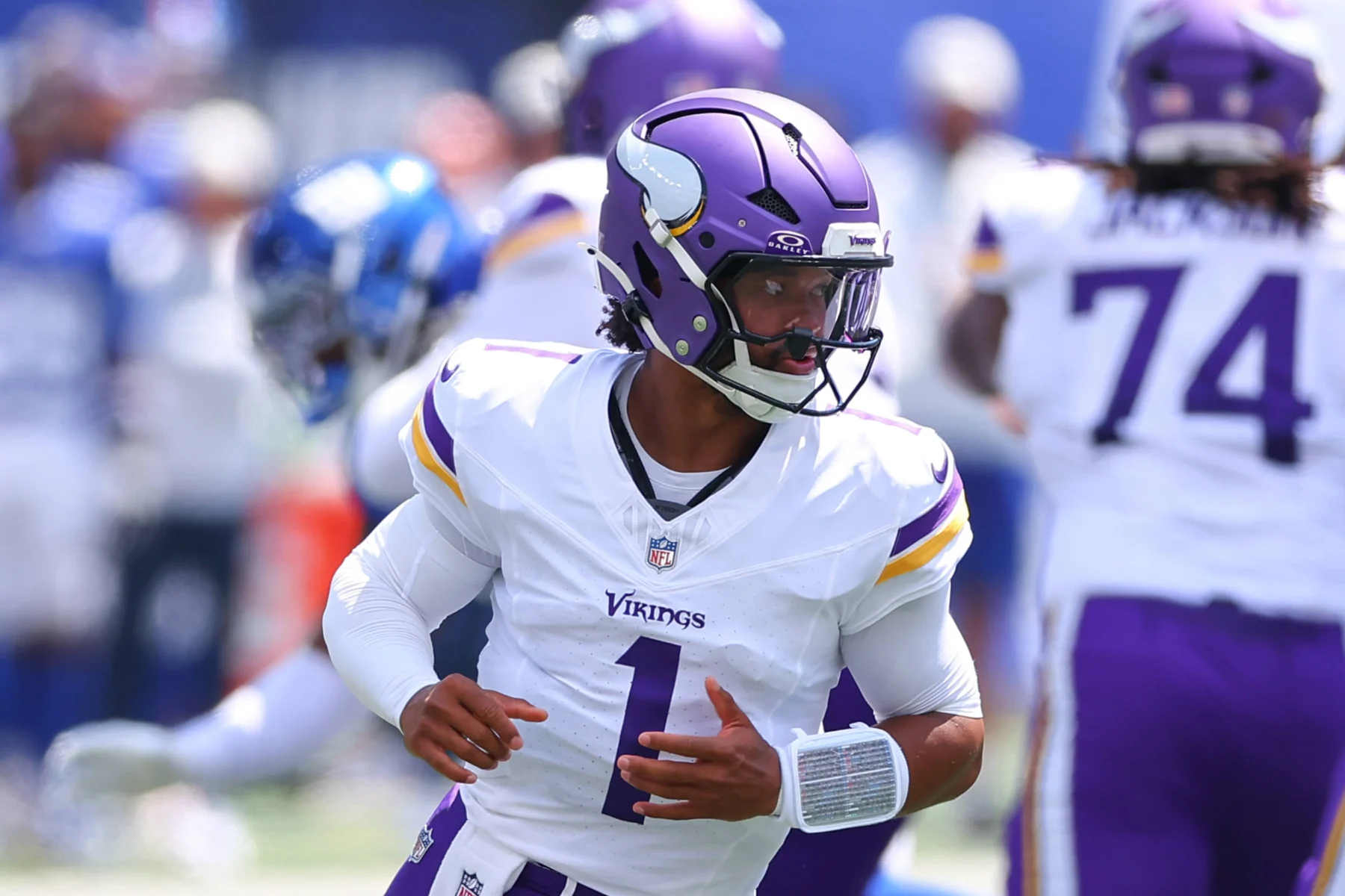 Der Quarterback der Minnesota Vikings in weiß-lila Trikot blickt während eines Footballspiels nach links, im Hintergrund sind Teamkollegen und Gegner zu sehen, während die Nachricht bekannt wird, dass Kyler Murray die Vikings verlässt. Alt-Text wurde KI-generiert.