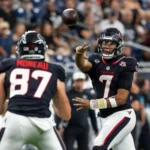 Der Quarterback der Houston Texans - C.J. Stroud - wirft während eines NFL-Spiels einen Pass zu einem Mitspieler mit der Rückennummer 87, im Hintergrund ist das Publikum zu sehen – ein Bericht: Die Texans und Stroud wenden das Blatt zugunsten ihrer Mannschaft. Alt-Text wurde KI-generiert.