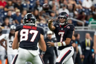Der Quarterback der Houston Texans - C.J. Stroud - wirft während eines NFL-Spiels einen Pass zu einem Mitspieler mit der Rückennummer 87, im Hintergrund ist das Publikum zu sehen – ein Bericht: Die Texans und Stroud wenden das Blatt zugunsten ihrer Mannschaft. Alt-Text wurde KI-generiert.