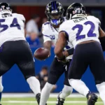 NFL Woche 3 - Lamar Jackson - Ein Quarterback im American Football übergibt den Ball während eines Spielzugs an einen Runningback, während im Hintergrund auf dem Spielfeld die Offensive Linemen die Verteidiger blocken – ein Bild, das die Intensität widerspiegelt, die man oft bei den Sonntagsspielen der ersten Woche der NFL sieht, und das Fans und Trainern gleichermaßen erste Erkenntnisse liefert. Alt-Text wurde KI-generiert.
