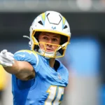 Ladd McConkey - Ein Footballspieler in einem blauen Trikot und Helm der Los Angeles Chargers – der möglicherweise einspringt, während Chargers-Spieler McConkey wegen einer Rippenverletzung täglich untersucht wird – zeigt während eines Spiels mit ausgestrecktem rechten Arm in eine Richtung. Alt-Text wurde KI-generiert.