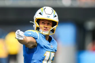 Ladd McConkey - Ein Footballspieler in einem blauen Trikot und Helm der Los Angeles Chargers – der möglicherweise einspringt, während Chargers-Spieler McConkey wegen einer Rippenverletzung täglich untersucht wird – zeigt während eines Spiels mit ausgestrecktem rechten Arm in eine Richtung. Alt-Text wurde KI-generiert.