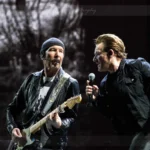 Bono singt in ein Mikrofon und The Edge spielt E-Gitarre auf der U2-Super-Bowl-Bühne.