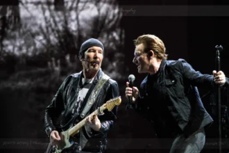 Bono singt in ein Mikrofon und The Edge spielt E-Gitarre auf der U2-Super-Bowl-Bühne.