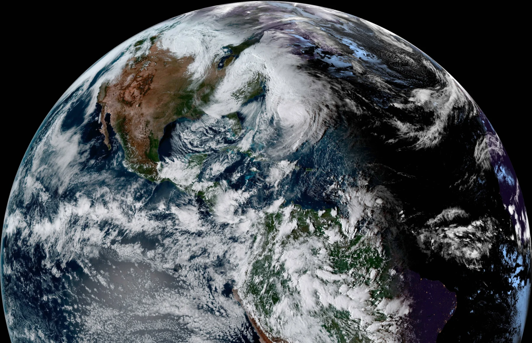 Satellitenbild von Nord- und Südamerika, wo ein großes Sturmsystem, das über dem Atlantik tobt, Tropensturmgefahr für die Region mit sich bringt. Alt-Text wurde KI-generiert.