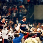 Spieler der Chicago Bears und Trainer Mike Ditka werden nach einem Sieg von Fans und Mannschaftskollegen vom Spielfeld getragen. Alt-Text wurde KI-generiert.