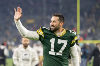 Brandon McManus trägt ein Trikot der Green Bay Packers und winkt der Menge zu.