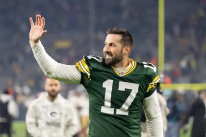 Brandon McManus trägt ein Trikot der Green Bay Packers und winkt der Menge zu.