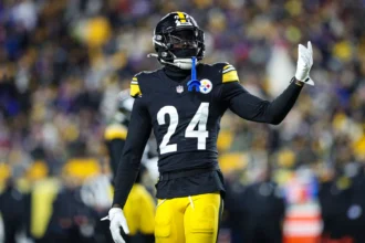 Joey Porter Jr. - Ein Footballspieler in einem schwarz-gelben Trikot der Porter Cowboys mit der Rückennummer 24 gestikuliert während eines Spiels auf dem Spielfeld. Alt-Text wurde KI-generiert.