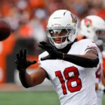 Marvin Harrison Jr - Der Wide Receiver mit der Nummer 18 der Arizona Cardinals streckt die Arme aus, um den Football zu fangen, während die Cardinals kurz vor einem Touchdown stehen. Alt-Text wurde KI-generiert.