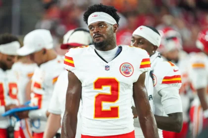 Tyquan Thornton, Wide Receiver der Chiefs, steht während eines Spiels in einem weißen Trikot der Kansas City Chiefs mit der Nummer 2 an der Seitenlinie, im Hintergrund sind seine Teamkollegen und die Stadionbeleuchtung zu sehen. Alt-Text wurde KI-generiert.