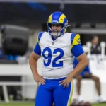 Harrison Mevis - Ein Spieler der Los Angeles Rams mit der Rückennummer 92 und einem blau-gelben Helm steht mit den Händen in den Hüften auf dem Spielfeld, nachdem Mevis entlassen wurde. Alt-Text wurde KI-generiert.