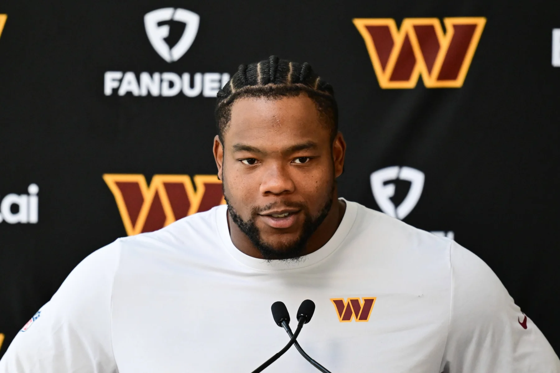 Daron Payne spricht vor einer Pressekonferenzwand der Washington Commanders.