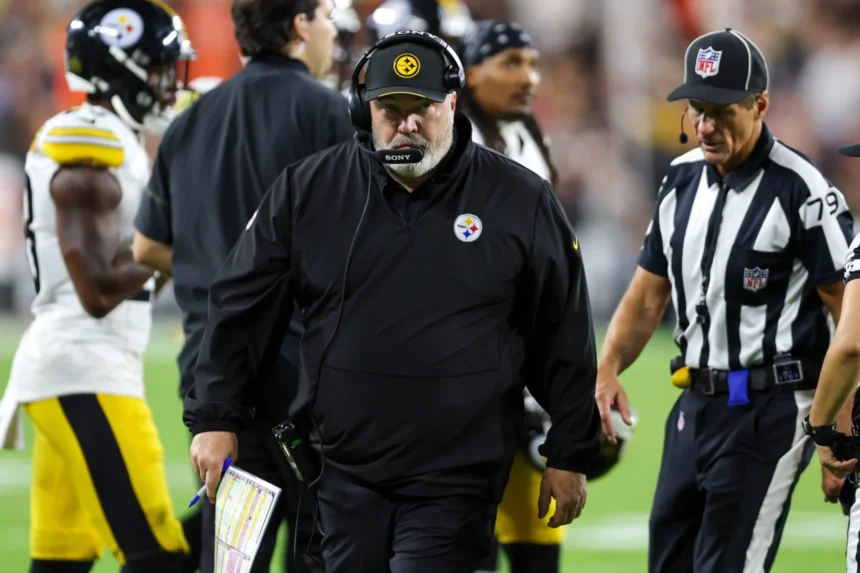 Mike McCarthy, Cheftrainer der Pittsburgh Steelers, trägt während eines Footballspiels ein Headset und eine schwarze Jacke.