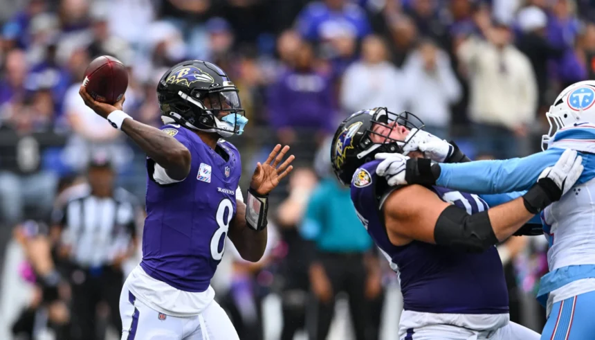 Lamar Jackson, Quarterback der Baltimore Ravens, bereitet sich während des „Sunday Night Football“-Spiels auf einen Pass vor, während ein Teamkollege einen Spieler der Tennessee Titans blockt. Alt-Text wurde KI-generiert.