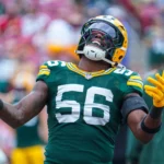 Edgerrin Cooper, Linebacker der Green Bay Packers mit der Rückennummer 56, jubelt mit ausgestreckten Armen und nach hinten geneigtem Kopf. Alt-Text wurde KI-generiert.