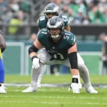 Cam Jurgens, Center der Philadelphia Eagles, in der Drei-Punkte-Haltung auf dem Spielfeld. Alt-Text wurde KI-generiert.