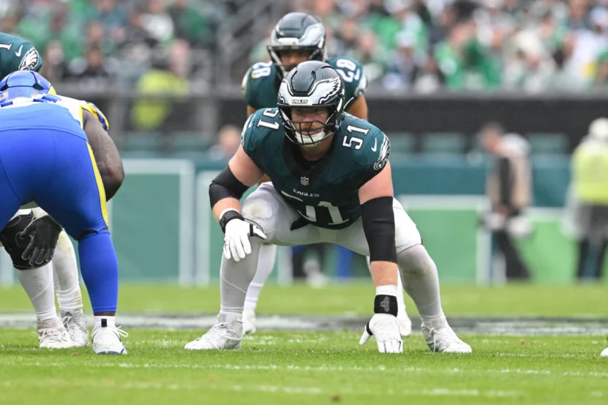 Cam Jurgens, Center der Philadelphia Eagles, in der Drei-Punkte-Haltung auf dem Spielfeld. Alt-Text wurde KI-generiert.