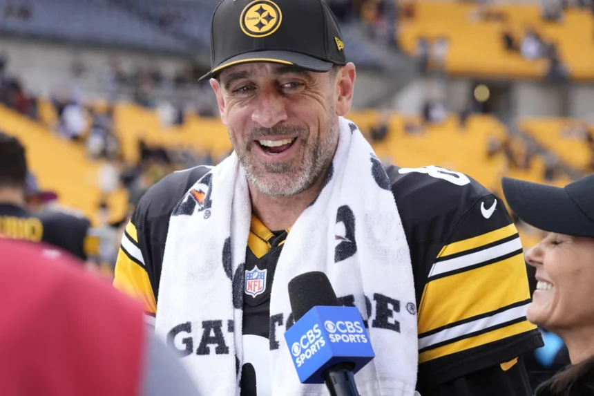 Aaron Rodgers - Ein Spieler der Pittsburgh Steelers in einem schwarz-gelben Trikot und einer Kappe spricht in ein CBS-Sports-Mikrofon.