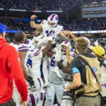 Spiel des Jahres - Die Spieler der Buffalo Bills heben einen Teamkollegen in die Luft, um einen Touchdown während der Verlängerung zu feiern, in der die Bills die Rams besiegten. Alt-Text wurde KI-generiert.