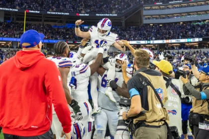Spiel des Jahres - Die Spieler der Buffalo Bills heben einen Teamkollegen in die Luft, um einen Touchdown während der Verlängerung zu feiern, in der die Bills die Rams besiegten. Alt-Text wurde KI-generiert.