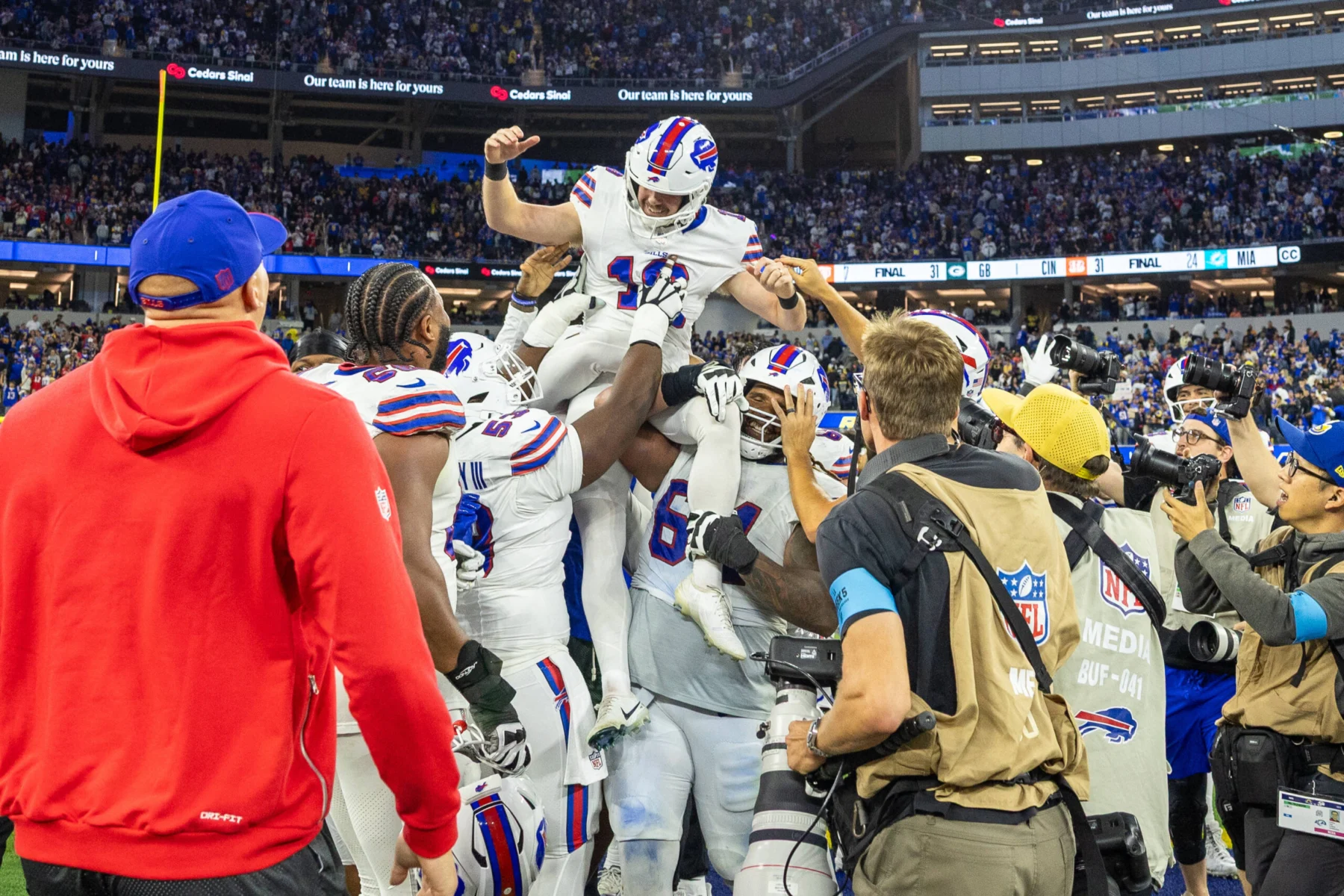Spiel des Jahres - Die Spieler der Buffalo Bills heben einen Teamkollegen in die Luft, um einen Touchdown während der Verlängerung zu feiern, in der die Bills die Rams besiegten. Alt-Text wurde KI-generiert.