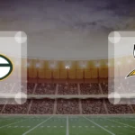 Eine Gamecard Grafik fuer das Spiel zwischen den Green Bay Packers und Minnesota Vikings am 14.09.26. die zwei Teamlogos stehen sich in einem Stadion mit vielen Zuschauern gegenueber.