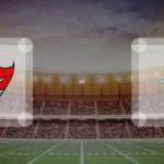 Eine Gamecard Grafik fuer das Spiel zwischen den Tampa Bay Buccaneers und Detroit Lions am 22.11.26. die zwei Teamlogos stehen sich in einem Stadion mit vielen Zuschauern gegenueber.