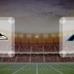 Eine Gamecard Grafik fuer das Spiel zwischen den Baltimore Ravens und Carolina Panthers am 22.11.26. die zwei Teamlogos stehen sich in einem Stadion mit vielen Zuschauern gegenueber.