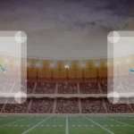 Eine Gamecard Grafik fuer das Spiel zwischen den Los Angeles Chargers und Miami Dolphins am 27.12.26. die zwei Teamlogos stehen sich in einem Stadion mit vielen Zuschauern gegenueber.