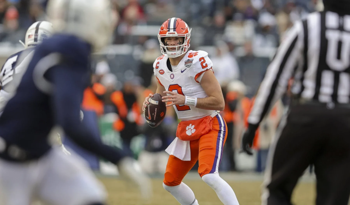 Quarterback in weiß-orange Trikot mit Ball in der Hand beim NCAA Football Spiel Clemson gegen Penn State im Pinstripe Bowl 2025