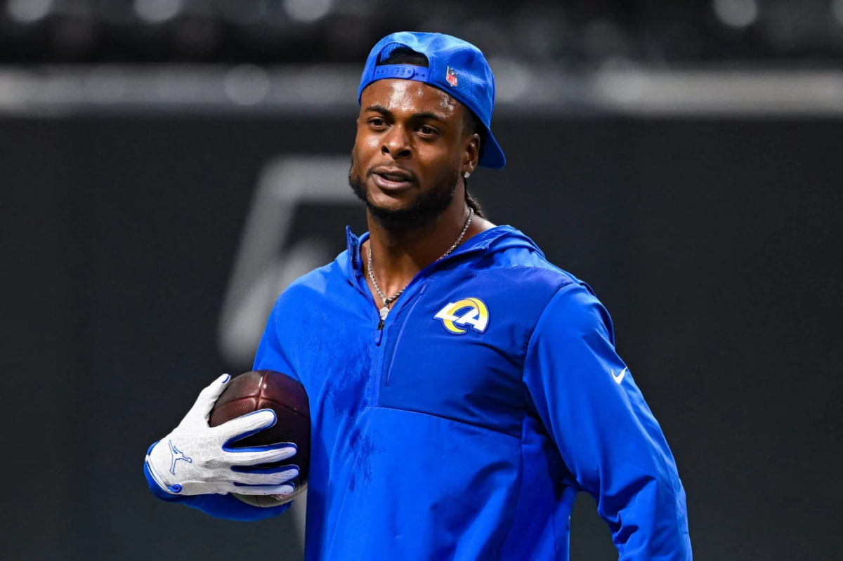 Footballspieler der Los Angeles Rams mit blauem Kapuzenpullover und Football in der Hand, blaue Kappe rückwärts getragen