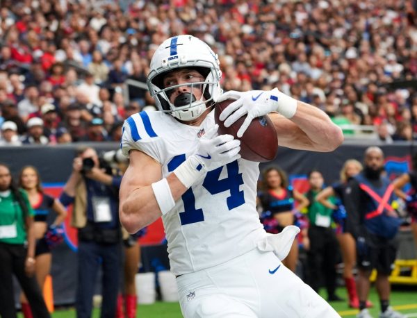 Alec Pierce, im weißen Trikot der Colts, fängt während eines Spiels einen Pass ab, während im Hintergrund die Zuschauer und Cheerleader zu sehen sind. Alt-Text wurde KI-generiert.