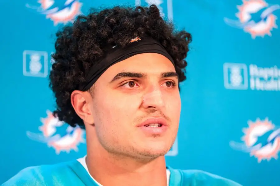 FootballR - NFL - Jaelan Phillips, ein Spieler der Miami Dolphins, mit lockigem Haar vor einem Mikrofon.
